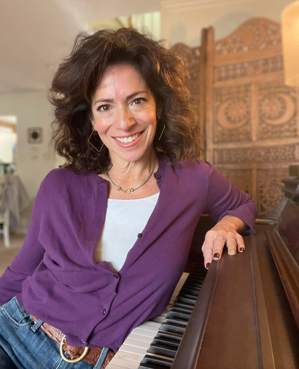 Marni Ratner smiling beside a piano