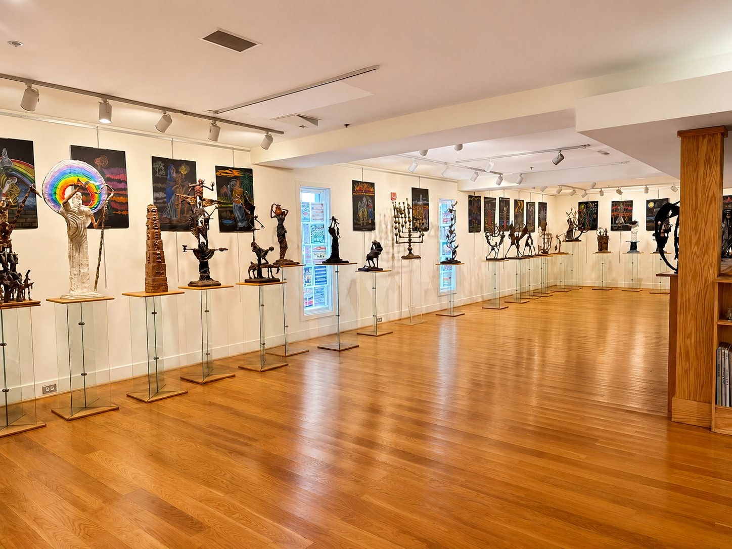 Phillip Ratner's second-floor sculpture gallery, with bronze figurative sculptures on pedestals along a wood-floored room
